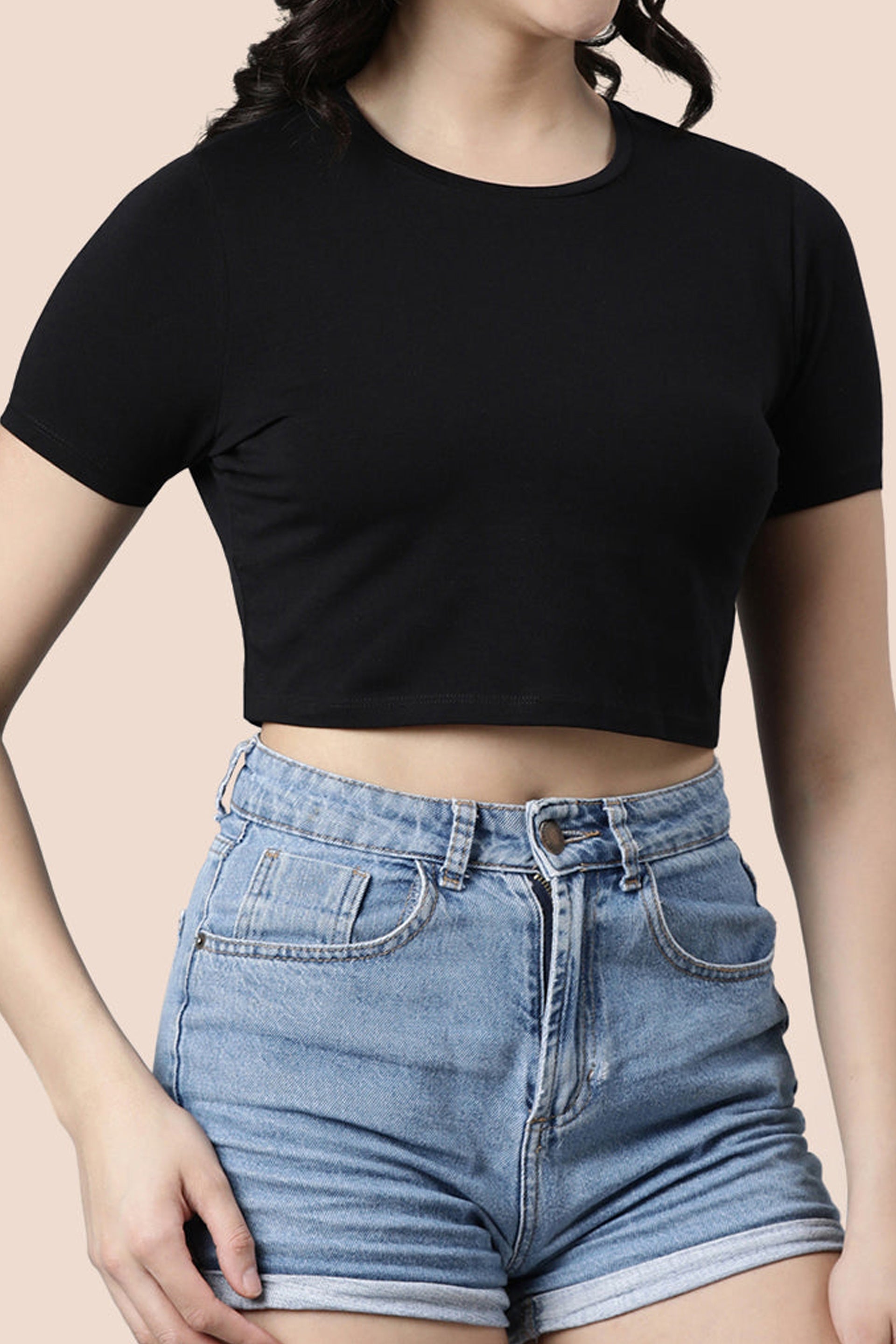 Classic black women's fashion crop top paired with high-waisted denim shorts for a trendy look