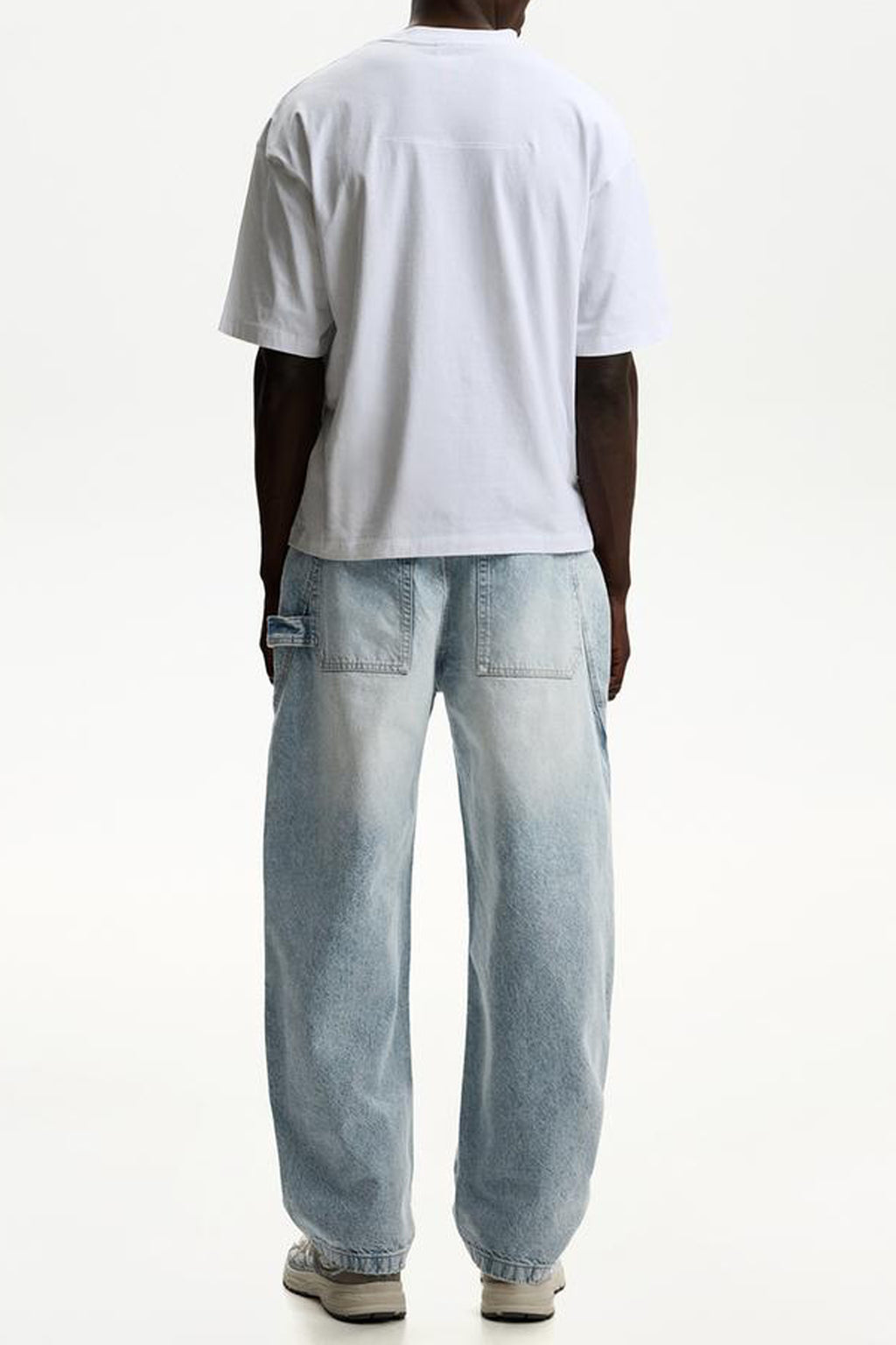 Casual outfit featuring balloon fit baggy jeans with a white t-shirt, shown from the back