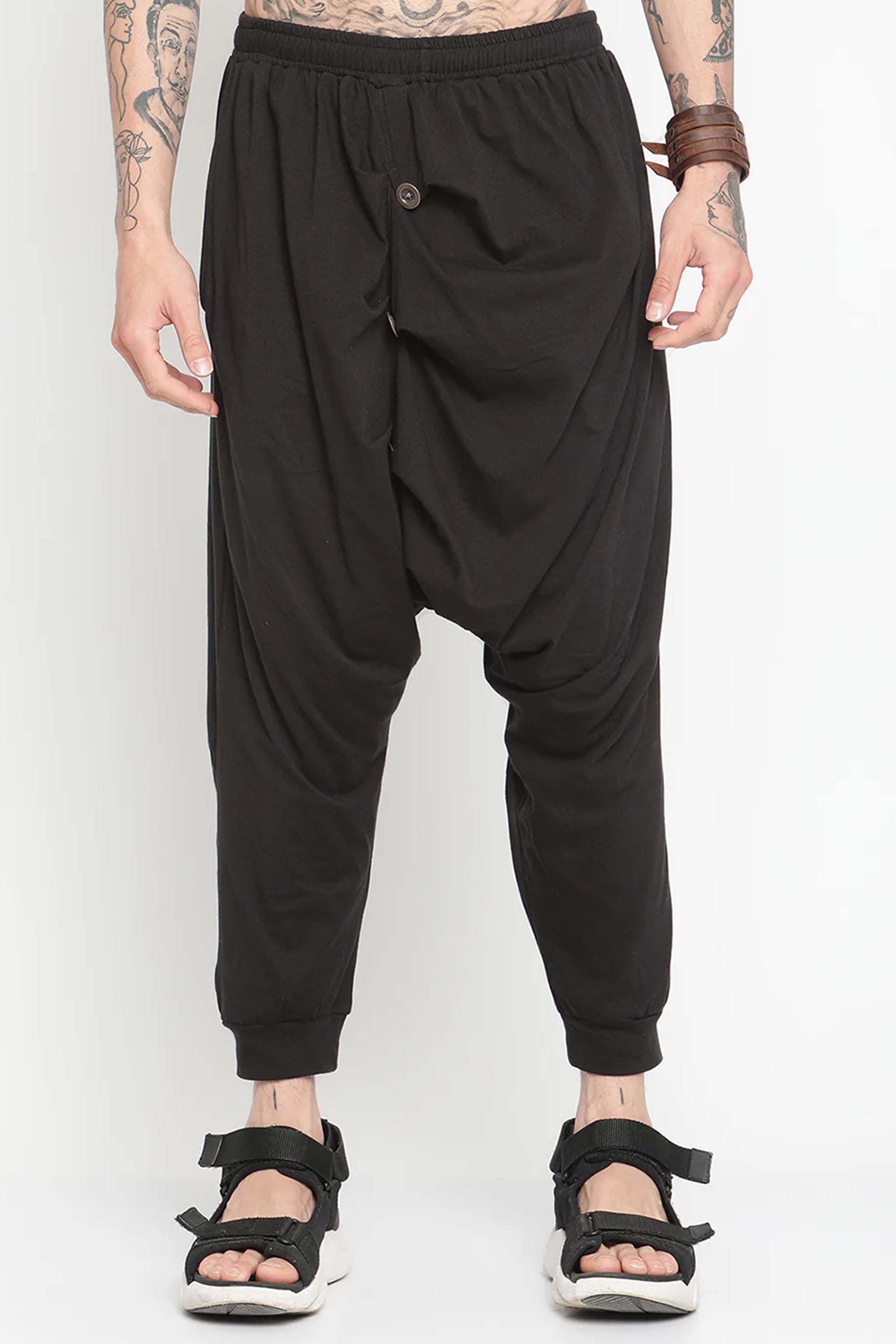 Men's black drop crotch harem pants with a relaxed fit and unique draping design