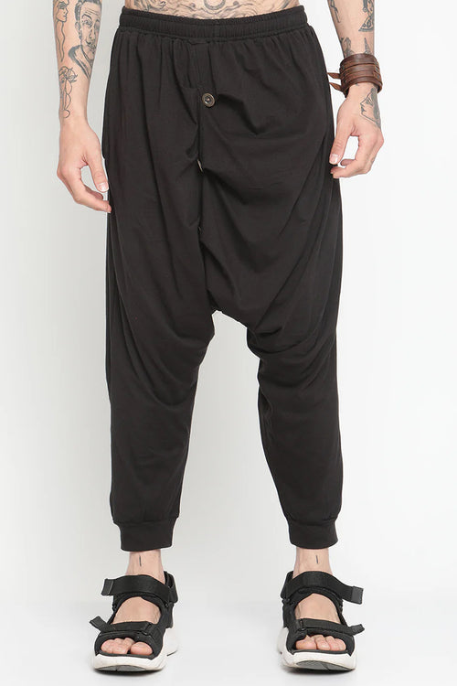 Men's black drop crotch harem pants with a relaxed fit and unique draping design