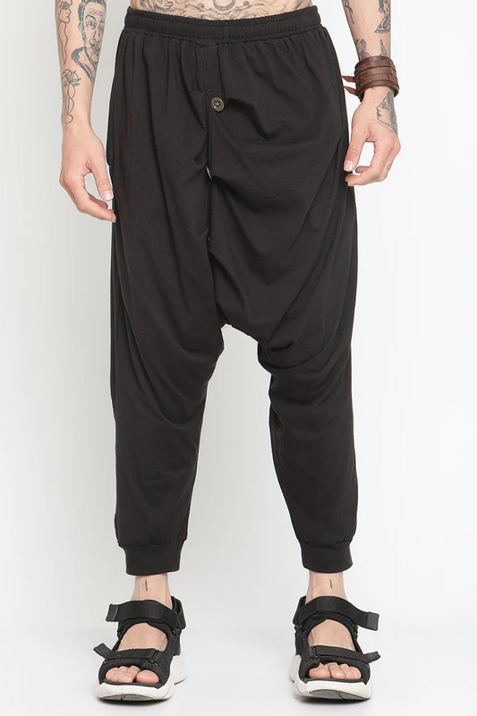 Men's black drop crotch harem pants with a relaxed fit and unique draping design