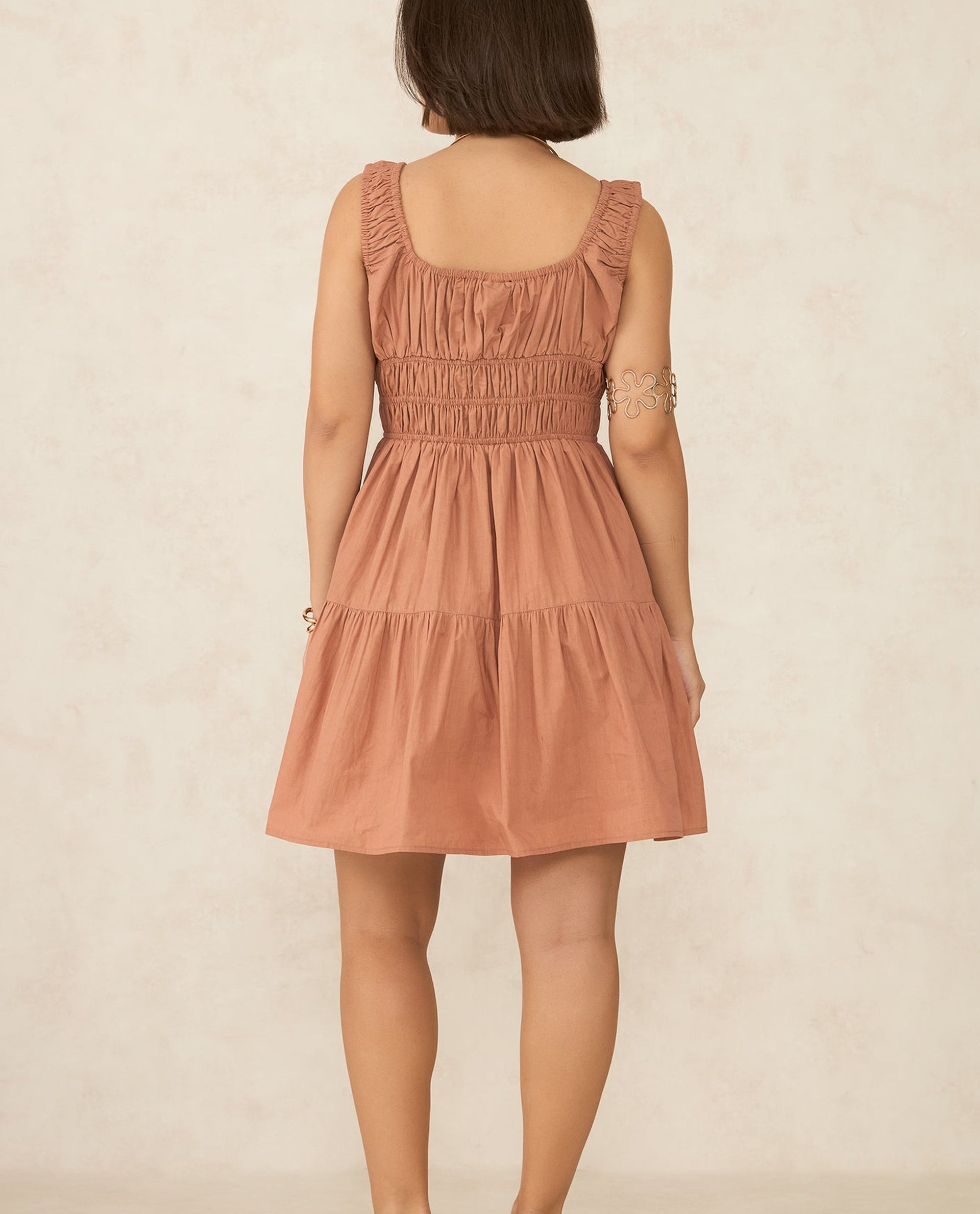 Back view of a Casual Mini Dress India in soft terracotta color with ruffled straps and smocked bodice
