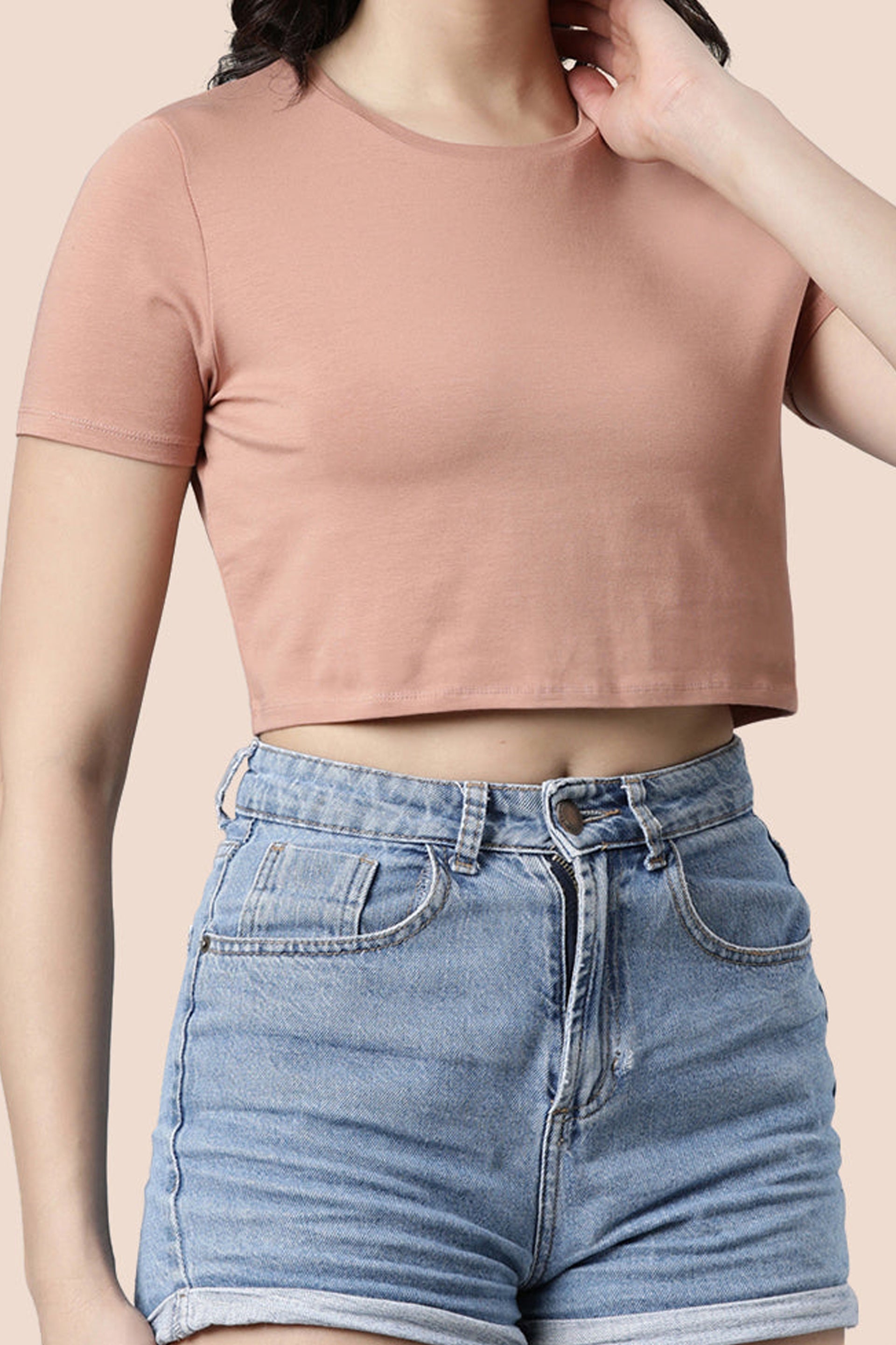 Casual summer tops women in peach color with a cropped design and short sleeves paired with denim shorts