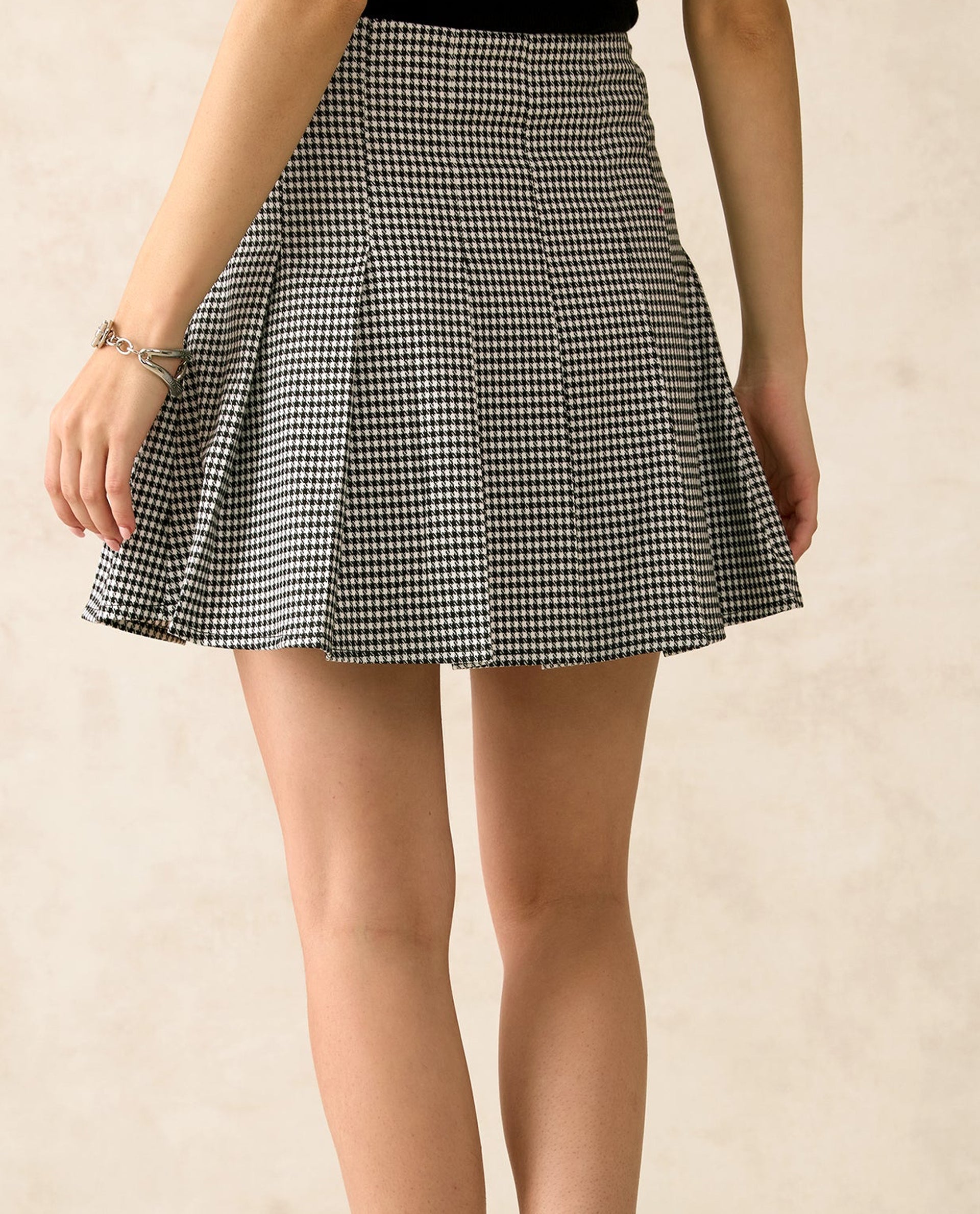 Back view of a checked mini pleated skirt by dirtylabels with a stylish design
