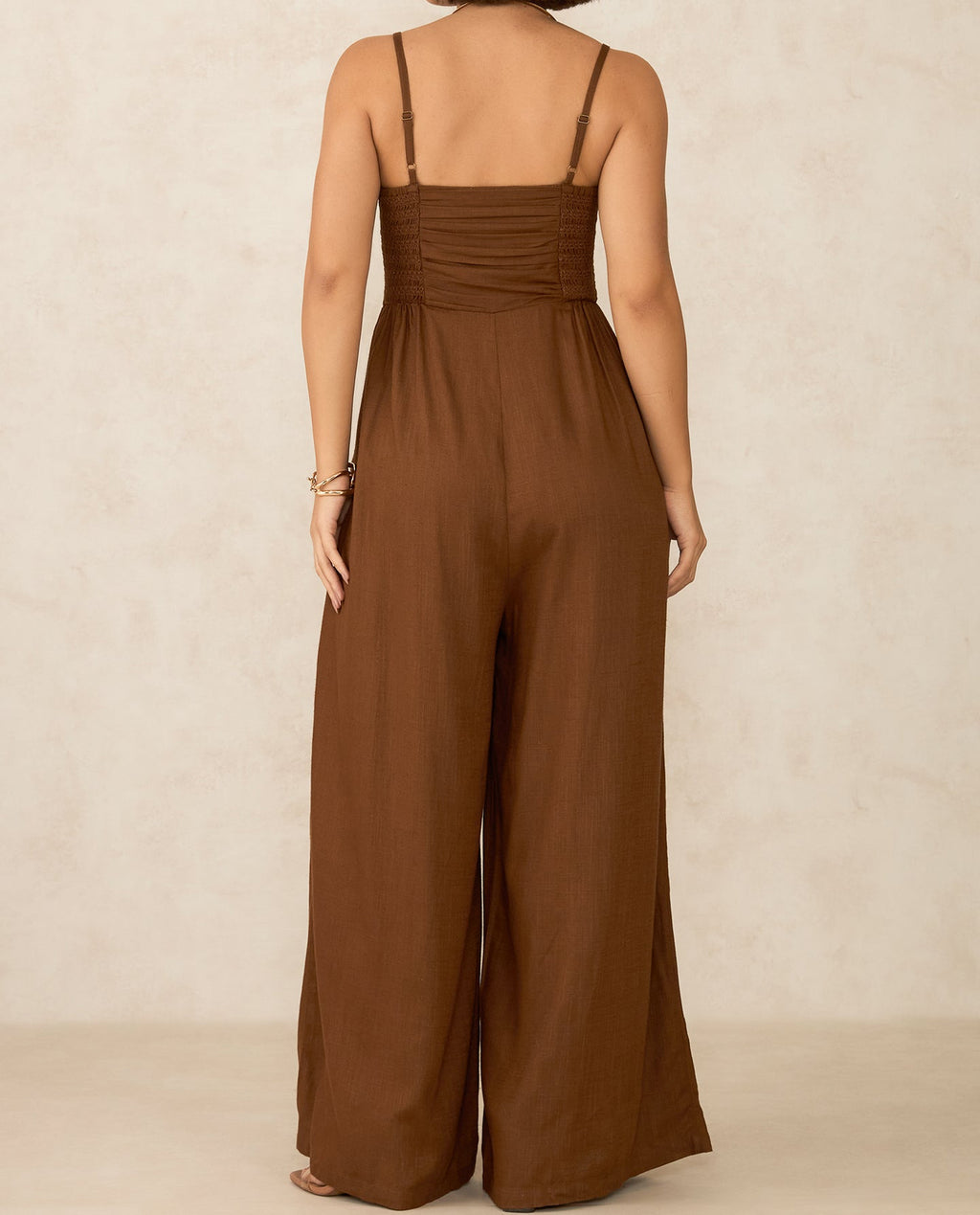 Back view of a brown elegant jumpsuit for parties with wide leg design and adjustable straps