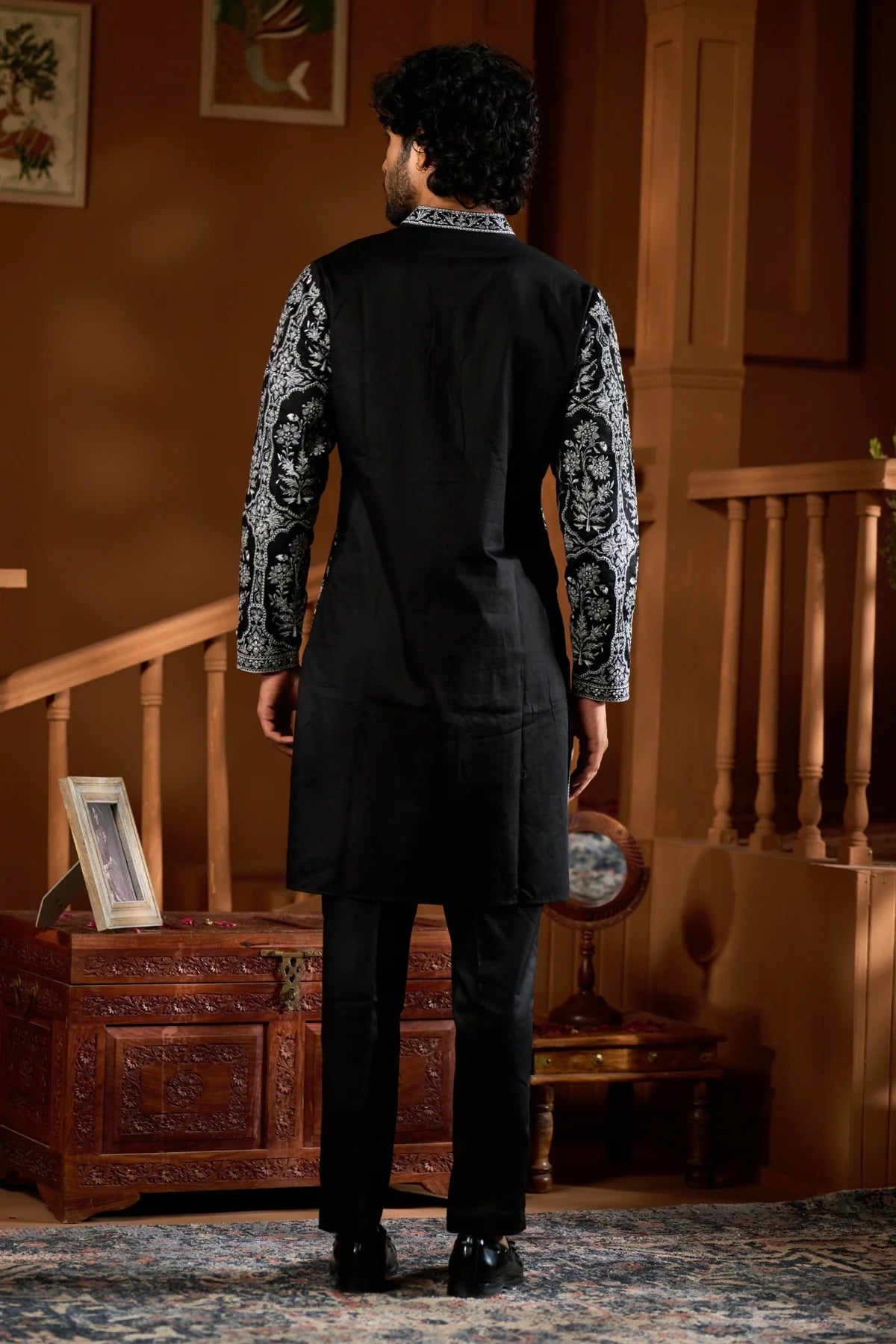 Back view of a festive men's ethnic wear set in black with decorative sleeves for special occasions