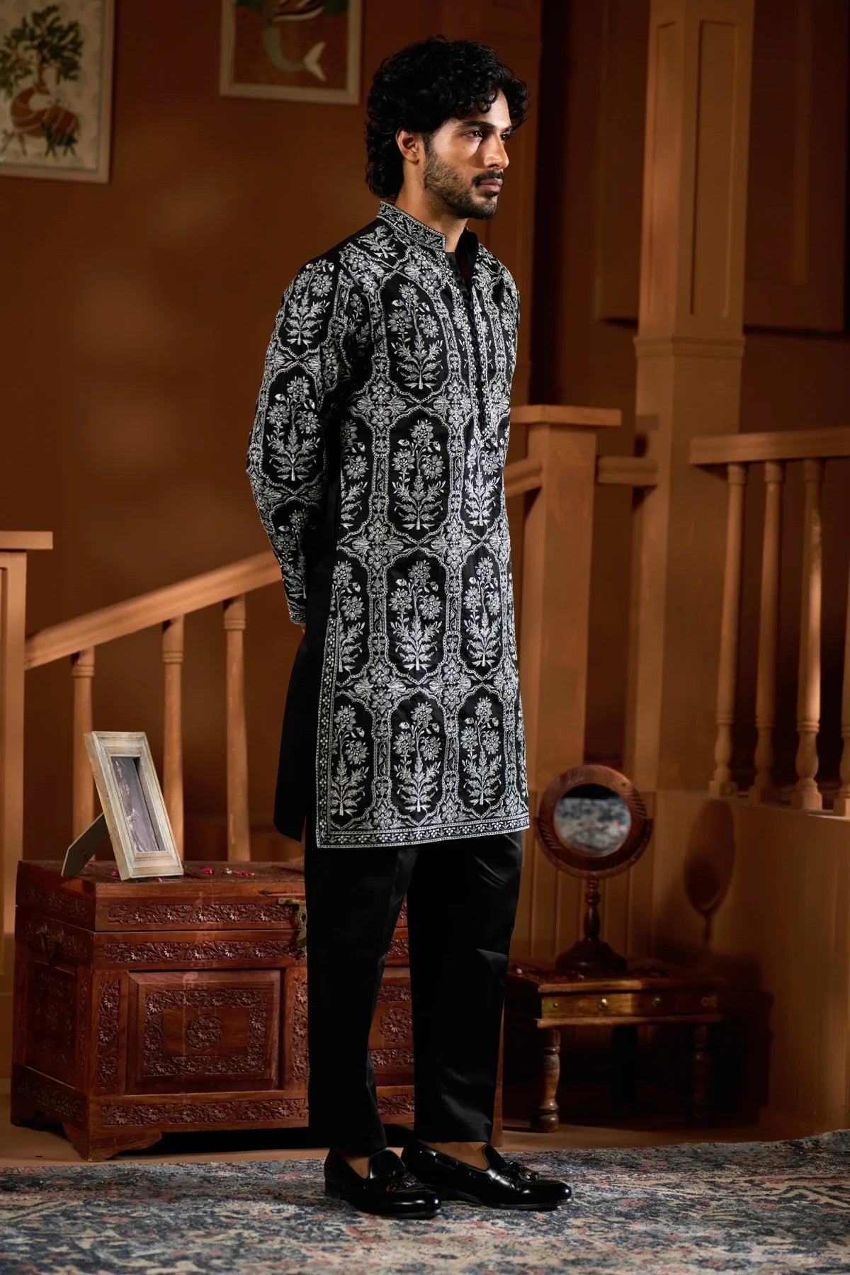 Elegant festive men's ethnic wear set featuring a black patterned kurta and matching trousers