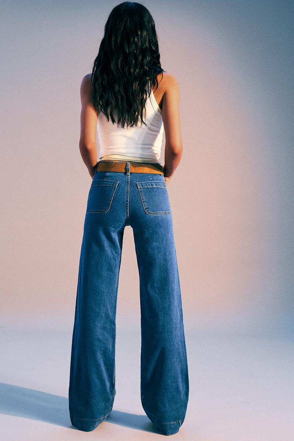 Back view of women in cropped wide-leg jeans women, featuring a relaxed fit and stylish design.