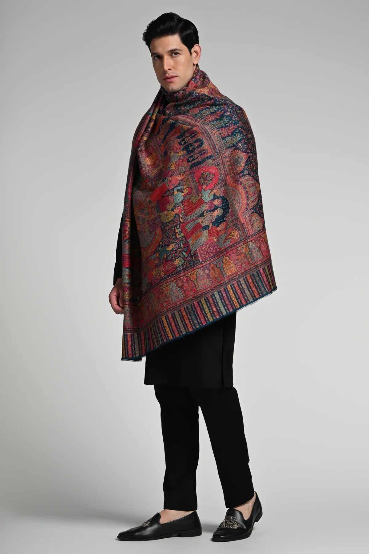 Elegant man draped in a luxury ethnic shawl for winter featuring intricate designs and rich colors