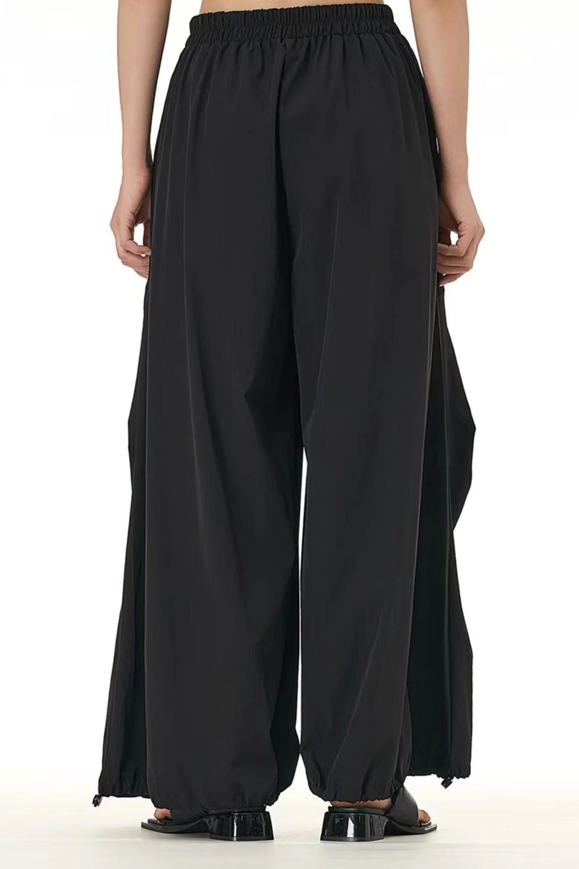 Back view of modern black trousers for women featuring a loose fit and elastic waistband