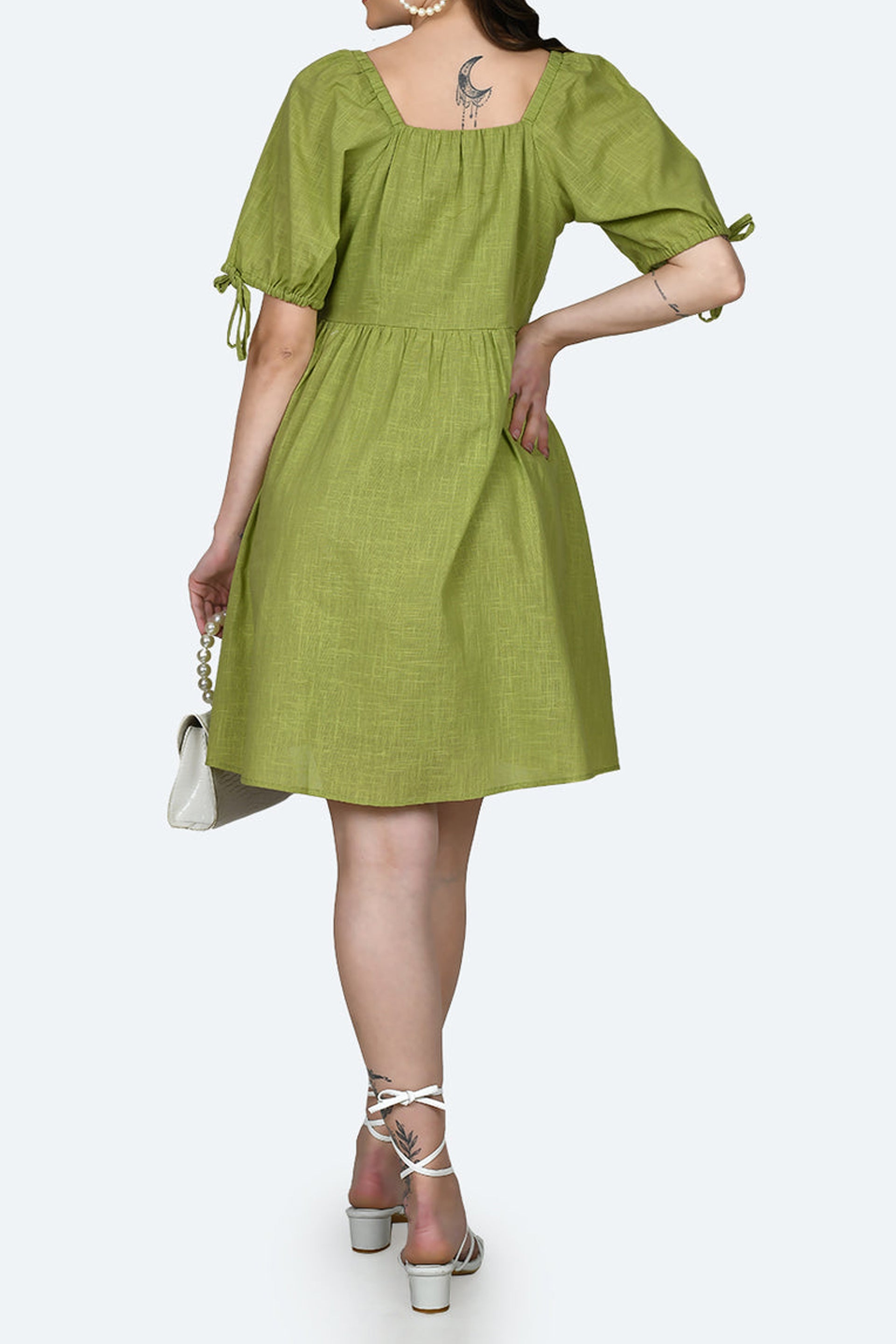 Back view of a stylish green short dress with puff sleeves by Dirty Labels for casual outings