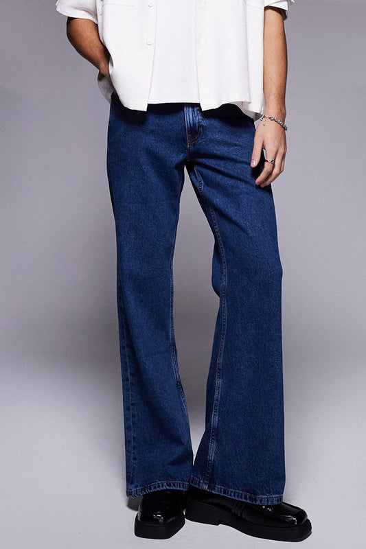 Model wearing vintage flared jeans for women in dark blue with a relaxed fit and wide leg design