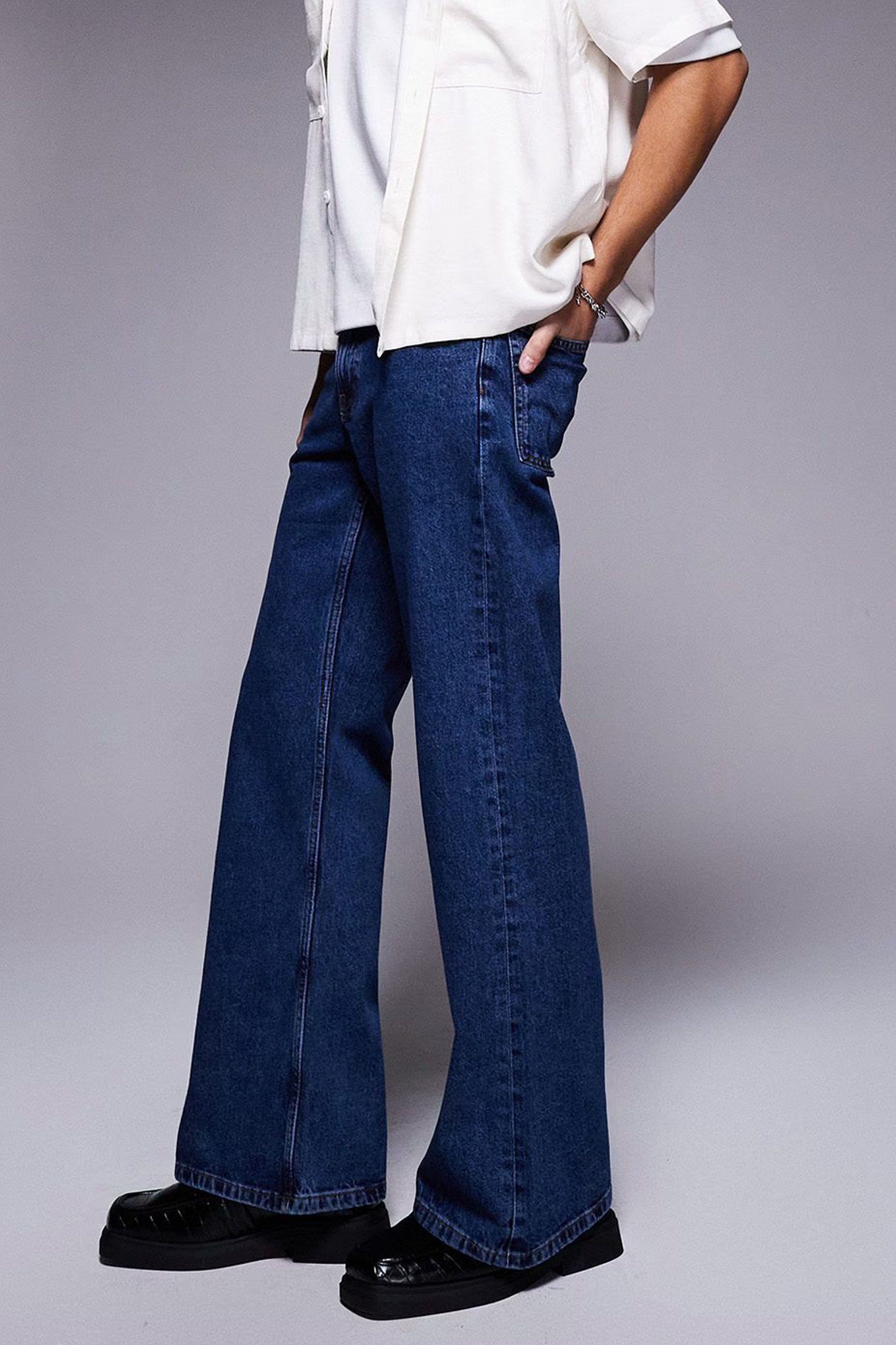 Model wearing vintage flared jeans for women styled with a white shirt and black shoes