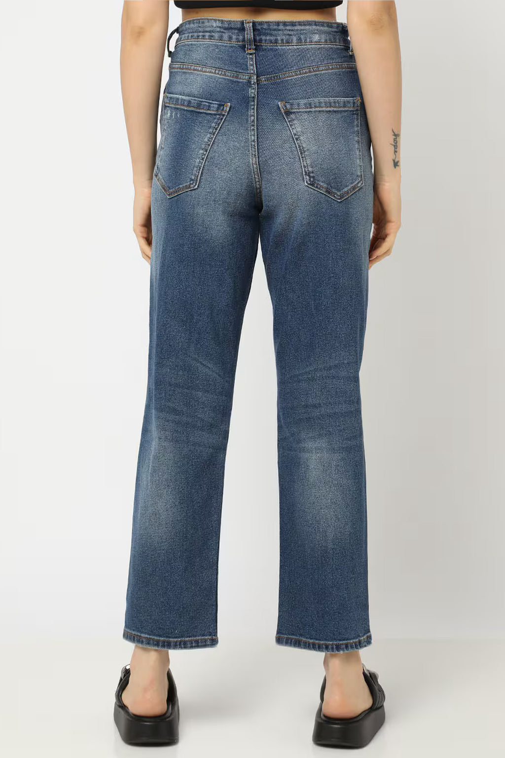 Back view of Women distressed bootcut jeans in blue denim with a relaxed fit for casual wear