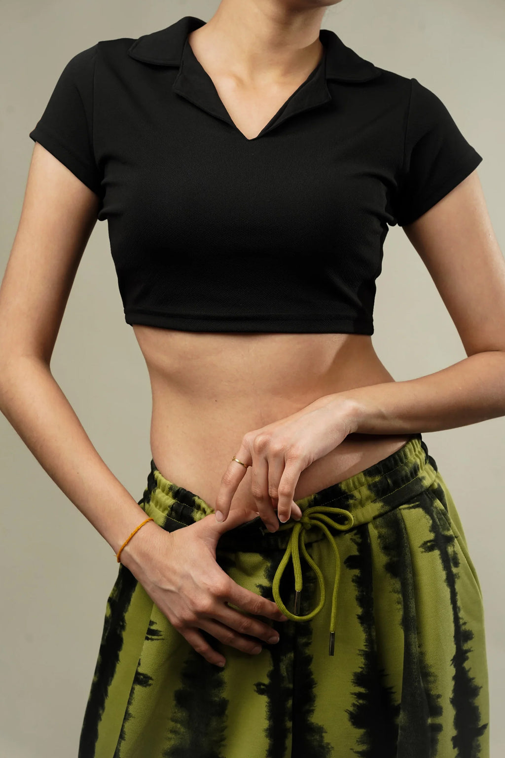 Model wearing a Women's Black Crop Top India with a collar, paired with green tie-dye pants