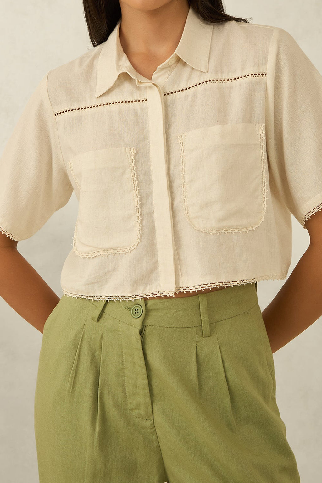 Women's cotton casual shirt in beige with decorative lace trim and two pockets, styled with green pants