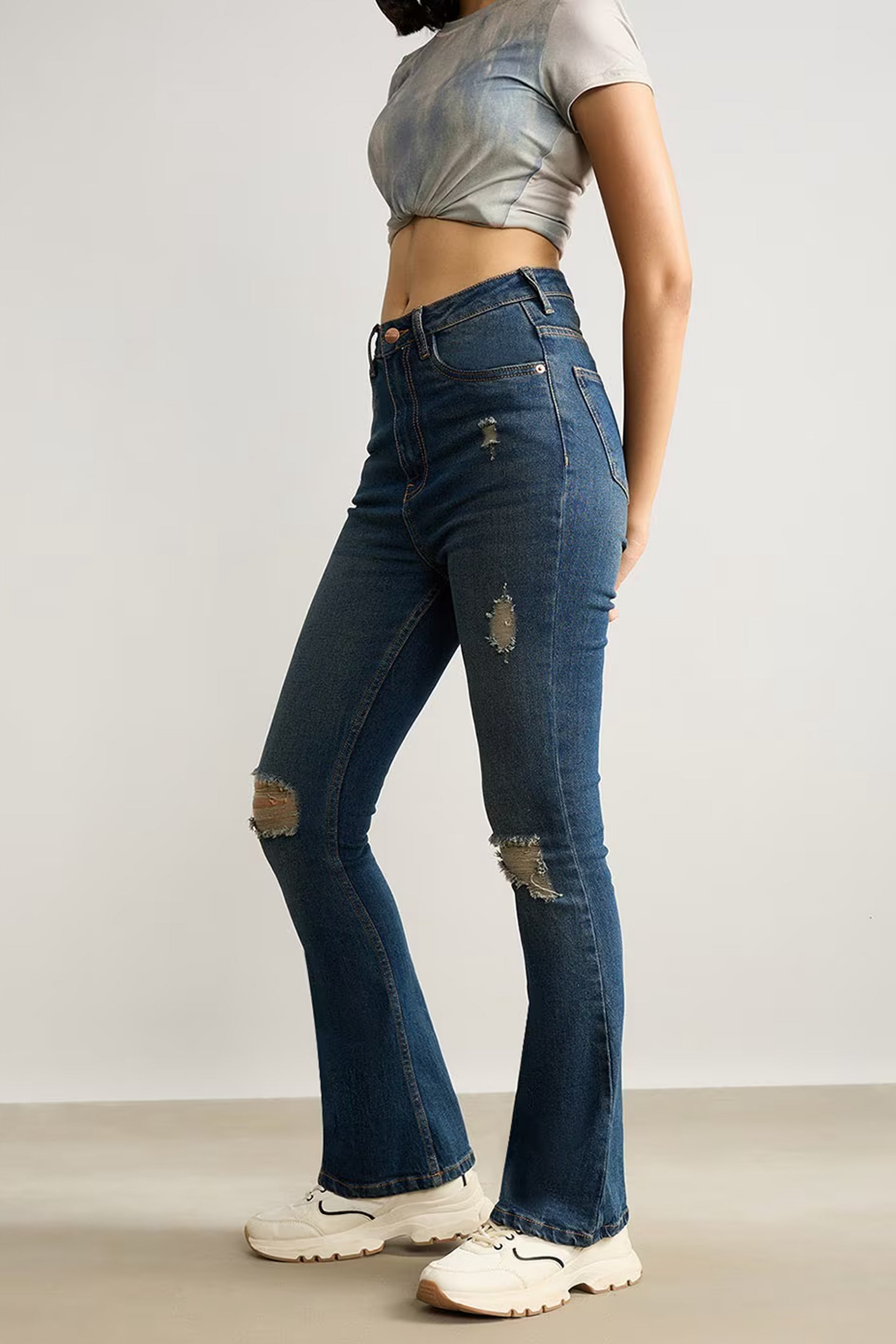 Women's distressed denim online featuring high-waisted flared jeans with ripped details and a slim fit