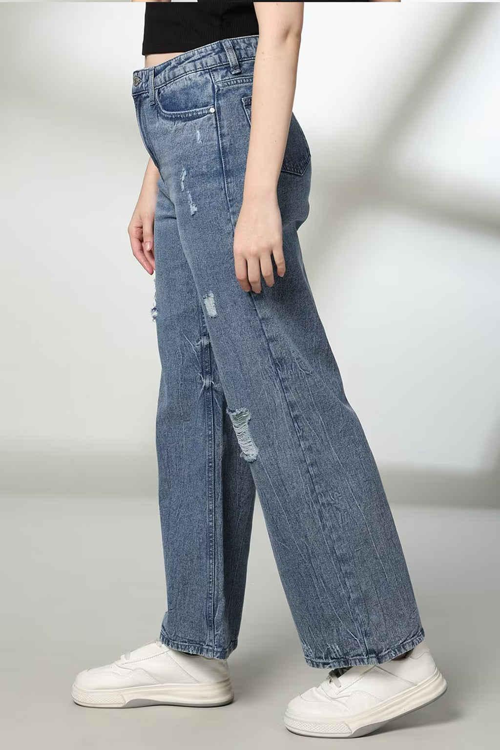 Side view of women's distressed wide-leg jeans with a relaxed fit and trendy ripped details