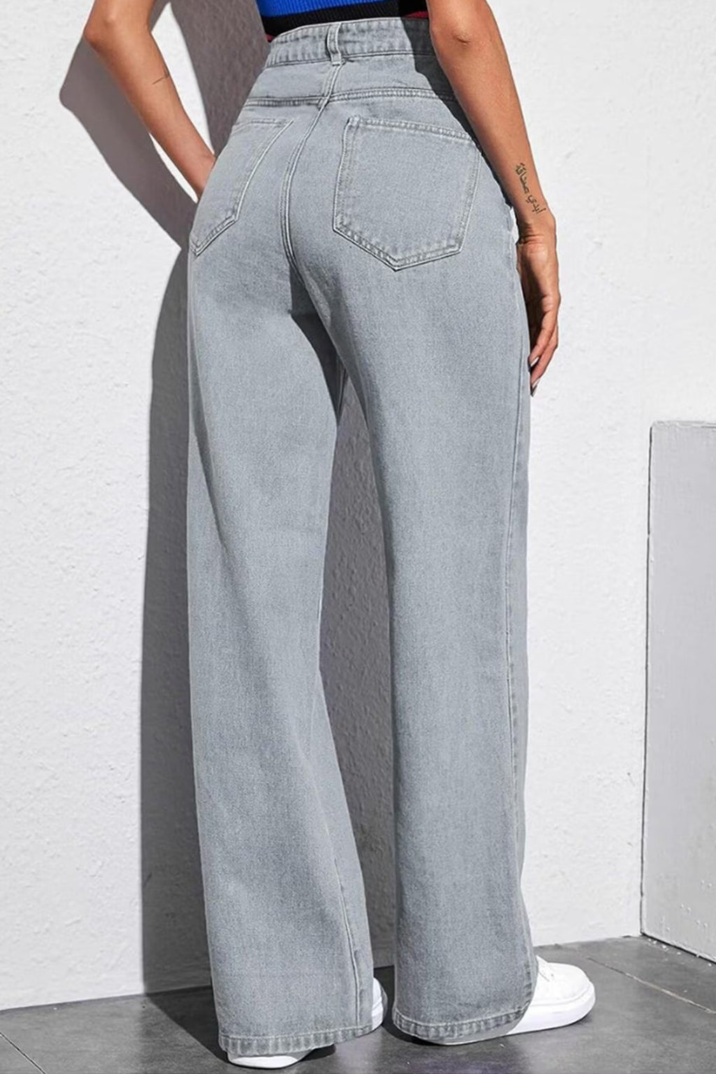 Back view of women's mid-rise grey jeans with a wide-leg fit and stylish design